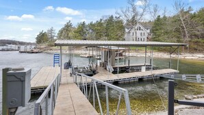 Un quai doté d’une zone de repos abritée, d’une rampe d’accès pour bateaux et d’une maison en arrière-plan.