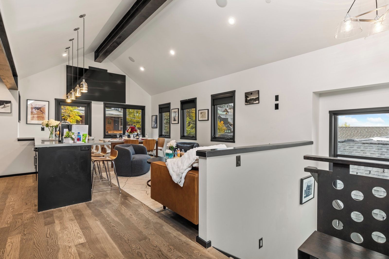 Un salon moderne comprenant un coin repas, une cuisine et une grande fenêtre offrant une vue dégagée.