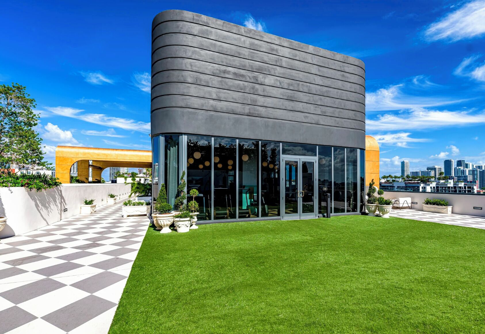 Un bâtiment moderne doté d ’une façade incurvée, de grandes fenêtres et d’un motif de carreaux au sol.