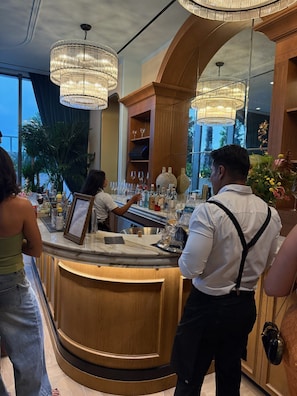 Eine Bar mit Holztresen, zahlreichen Flaschen, Gläsern und einem Menüständer.
