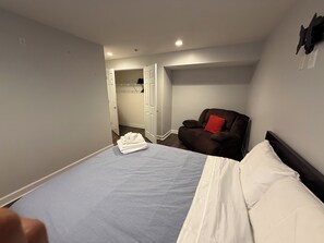 A bedroom with a bed, a chair, and a walk-in closet. - Cozy 2-bedroom basement in charming Gainesville (Gainesville)