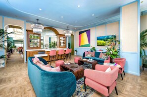 A modern hotel lobby with a bar, seating area, and a large colorful painting. - Luxury PH Wynwood 1BR | 2 Bed -1 Bath+Balc 4 Guest (Miami)