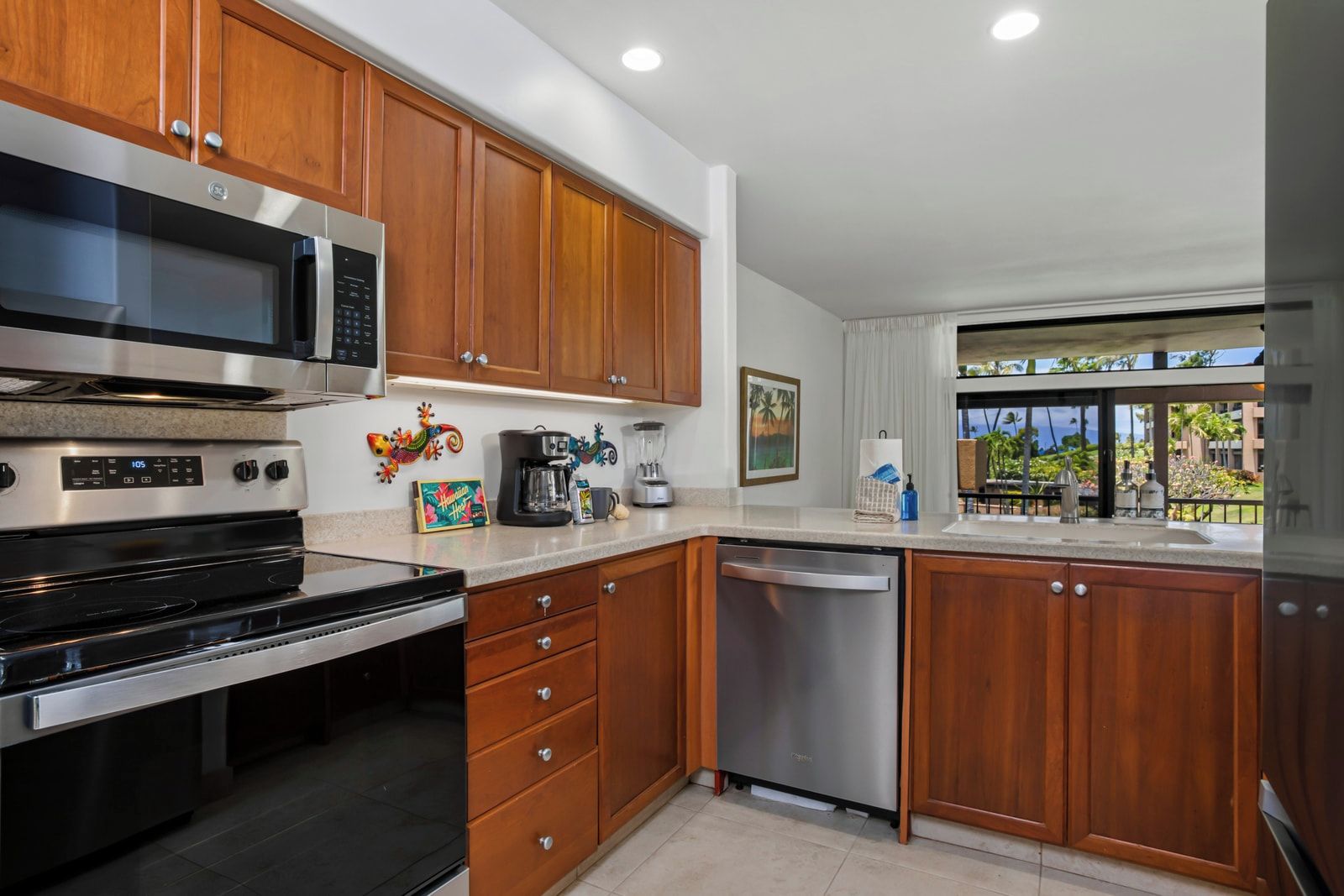 A modern kitchen with wooden cabinets, stainless steel appliances, and a view of the outdoors.