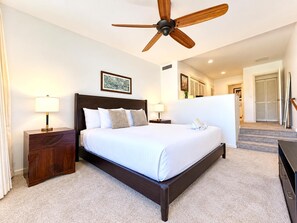 A hotel room with a large bed, two bedside tables, a ceiling fan, and a view of the hallway. - Kaanapali Royal 3 Garden View Villas, Sleeps 19 | Car Incl. w/6 nights | ML-3995 by KBM (Lahaina)