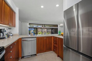 Eine moderne Küche mit Holzausstattung, Edelstahlgeräten und einem Geschirrspüler.