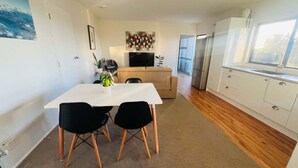 Una cocina funcional con comedor, sofá y televisor.