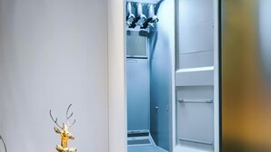 Ein moderner, gut beleuchteter Raum mit einem eingebauten Kühlschrank und einer kleinen, dekorativen Hirschstatue.