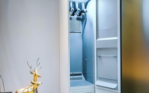 A modern, well-lit room with a built-in refrigerator and a small, decorative deer statue.
