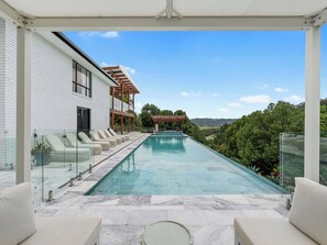 A modern house with a swimming pool, outdoor seating, and a view of the countryside. - Chateau on Cudgen minutes to beautiful Tweed coast beaches. Pool/hot tub/firepit (Stotts Creek)