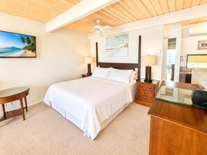 A hotel room with a bed, a desk, a chair, a ceiling fan, and artwork on the walls. - Napili Point 2 Water Front Villas, Sleeps 10 | Car Incl. w/ 6 nights | ML-4071 by KBM (Lahaina)