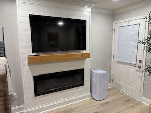 Una habitación con televisión integrada, chimenea y purificador de aire.
