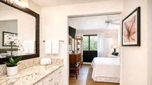 A hotel room with a marble bathroom, a bed, a desk, and a view of greenery. - Napili Point 2 Water Front Villas, Sleeps 10 | Car Incl. w/ 6 nights | ML-4080 by KBM (Lahaina)