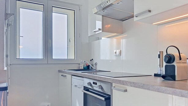 Una cocina moderna equipada con lavavajillas, horno y cafetera.
