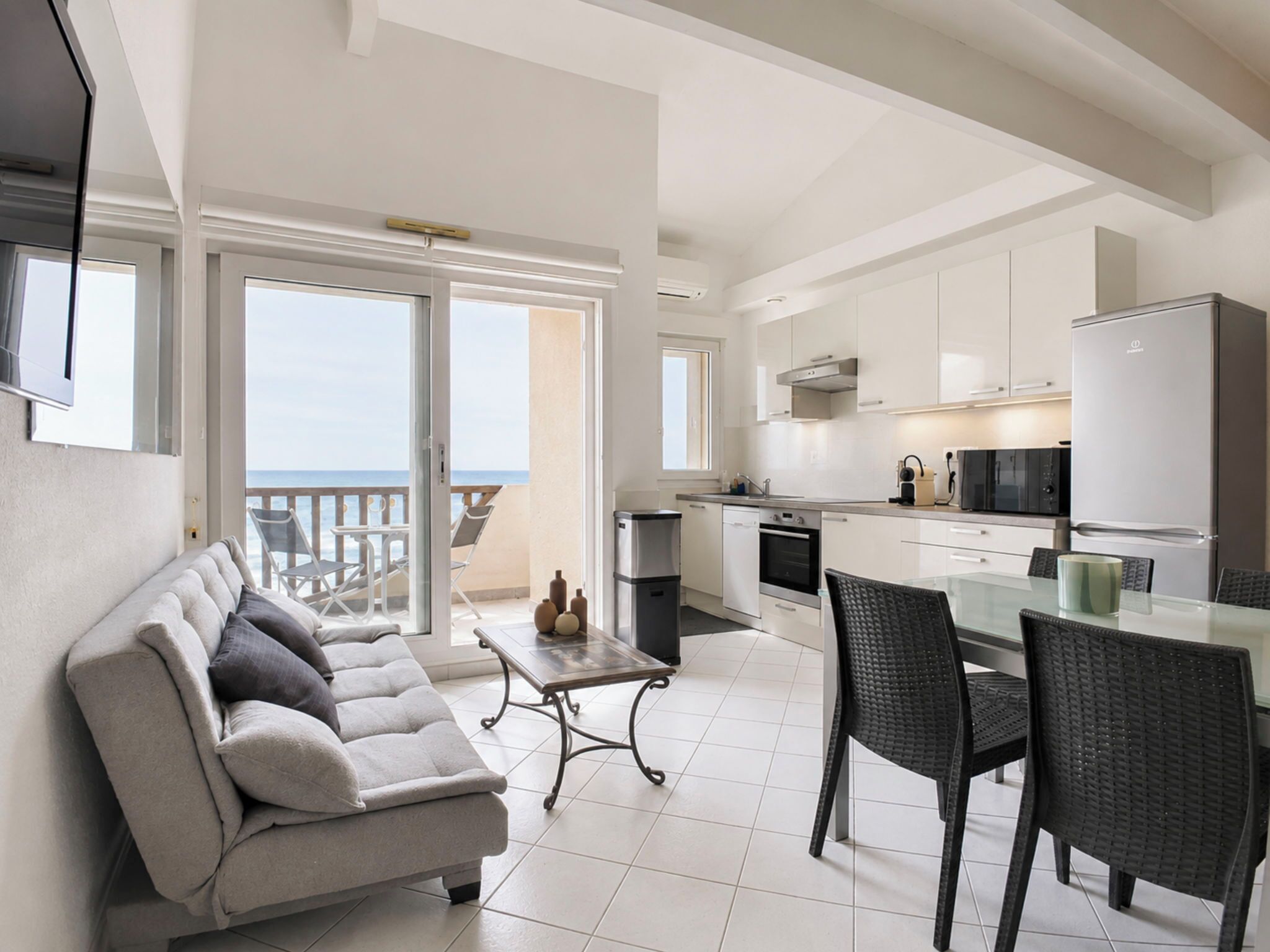 A modern apartment with a balcony, a kitchen, and a dining area.