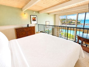 A bedroom with a large bed, wooden dresser, and a balcony with a view of the ocean. - Napili Point 3 Waterfront Villas, Sleeps 16 | Car Incl. w/ 6 nights | ML-4083 by KBM (Lahaina)
