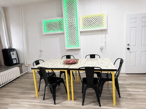 A dining area with a table, chairs, and a radiator.