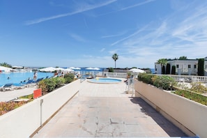 Ein Poolbereich mit mehreren Pools, Liegestühlen und Sonnenschirmen.