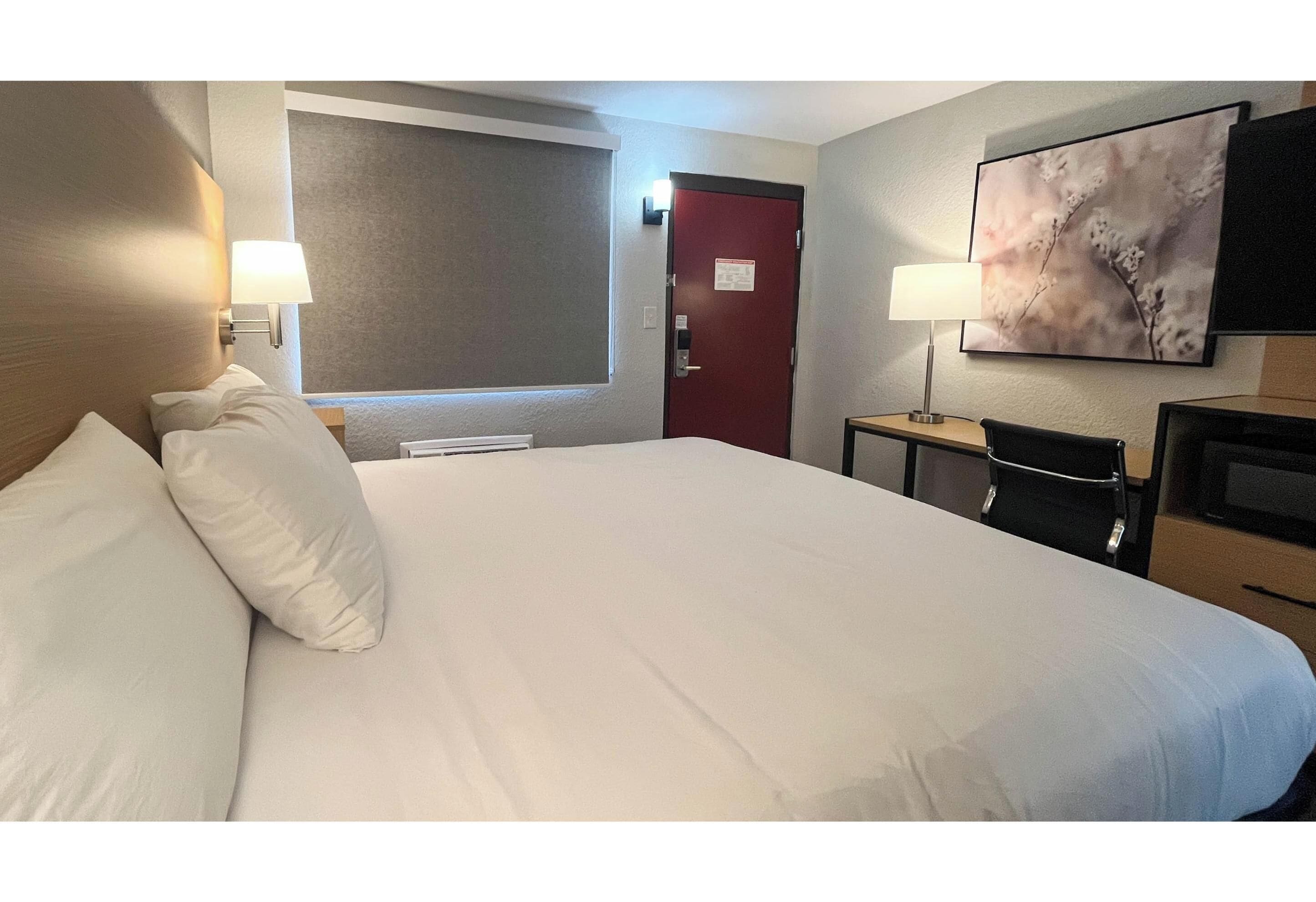 Premium bedding, desk, laptop workspace, blackout drapes
