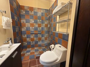Ein Badezimmer mit Dusche, Toilette und Waschbecken.