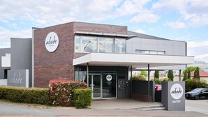 A modern building with a sign reading 'abode' and an 'ENTRY' sign. - Studio 1-bedroom apartment with AC in charming Gungahlin (Gungahlin)