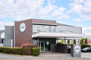 Ein modernes Gebäude mit einem Schild mit dem Schriftzug 'abode' und einem Schild mit der Aufschrift 'EINGANG'.