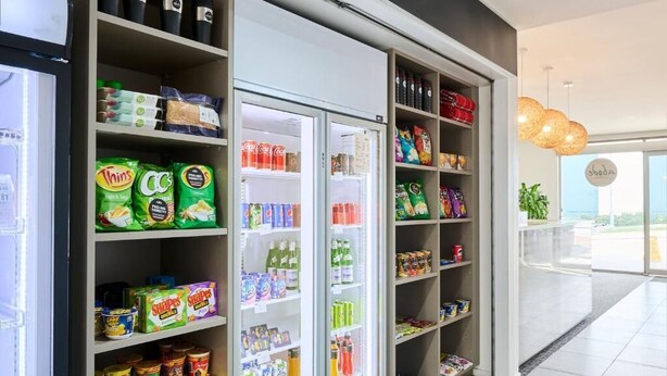 A grocery store interior with shelves stocked with snacks, beverages, and canned goods. - Studio 1-bedroom apartment with AC in charming Gungahlin (Gungahlin)
