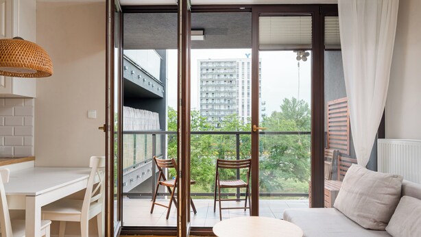 Un appartement moderne doté d’un balcon, d’un coin repas et d’un salon.