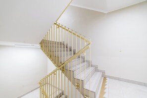 Eine Wendeltreppe mit gelber Metallrelinge in einem modernen Innenraum.