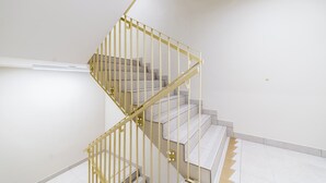 Een spiraaltrap met een geel metalen leuning in een modern interieur.