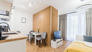Een moderne kamer met een keuken, eethoek en een bed.