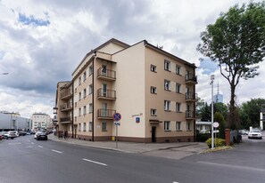 A multi-story residential building with balconies, a parking area, and a clear sky. - Jagiellońska Comfort Apartment (Rzeszów)
