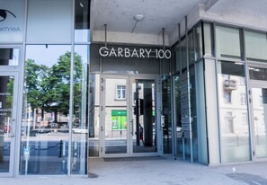 Une entrée d'immeuble avec une enseigne indiquant « GARDBARY 100 » et une porte en verre.