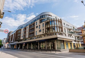 A modern building with a curved facade, large windows, and a ground-level entrance. - Warta River Chic Studio (Poznań)