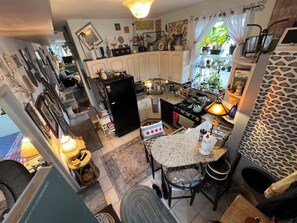 A compact kitchen with a refrigerator, stove, and dining area.