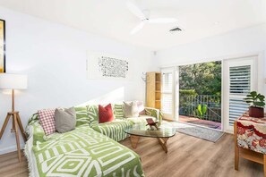 A modern living room with a sofa, coffee table, and a balcony with a railing. - SPRU7 - Neutral Bay Sanctuary | Sunlit Home (Neutral Bay)