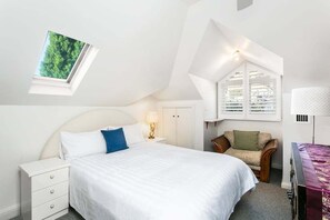 A bedroom with a bed, a nightstand, a chair, a desk, a lamp, a wardrobe, and a skylight. - SPRU7 - Neutral Bay Sanctuary | Sunlit Home (Neutral Bay)