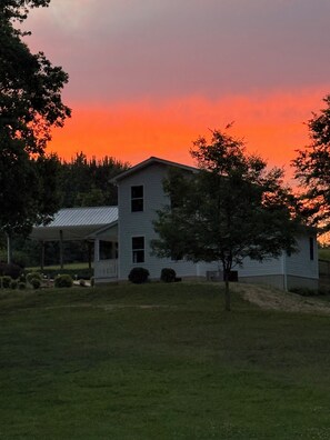 A single-story house with a gabled roof, surrounded by a grassy yard and trees. - Nana’s Cottage. Perfect 2 bedroom 1 bath home in a beautiful country setting (Attalla)