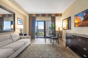 A hotel room with a sofa, dining table, chairs, a dresser, and a balcony with a view. - Ocean & Skyline View Penthouse 1bdrm Free Parking! (Honolulu)