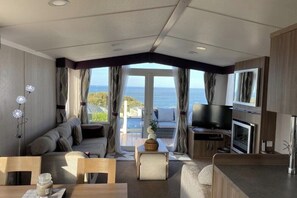 Ett modernt vardagsrum med soffa, matbord och TV.