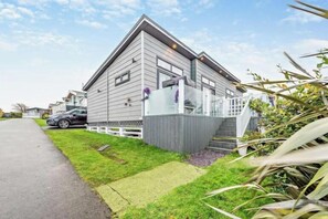 Ein modernes, zweistöckiges Haus mit Vorgarten, Auffahrt und geparktem Auto.