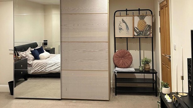 Une chambre à coucher avec un lit, une table de chevet et un miroir.