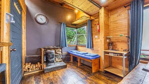 A cozy cabin with a stone fireplace, a bench, and a wooden table. - Jaulares Country House (Rivas)
