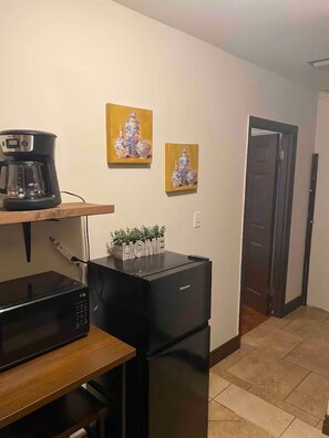 A kitchen with a coffee maker, microwave, refrigerator, and two paintings on the wall. - Private guest house (Bakersfield)