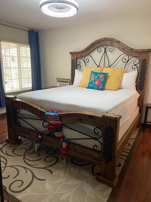 A neatly made bed with a wooden headboard and a decorative pillow. - Private guest house (Bakersfield)