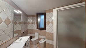 Une salle de bain moderne équipée de toilettes, d’un bidet et de deux lavabos.