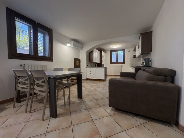 A compact living space with a dining area, kitchenette, and a sofa. - Vrbo Property (Porto Frailis)