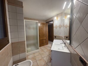 A bathroom with a shower, toilet, and sink. - Vrbo Property (Porto Frailis)
