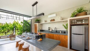 Una cucina moderna con una grande isola, sgabelli in legno e frigorifero integrato.
