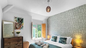 Ein Schlafzimmer mit Bett, Schminktisch und einem Bild an der Wand.
