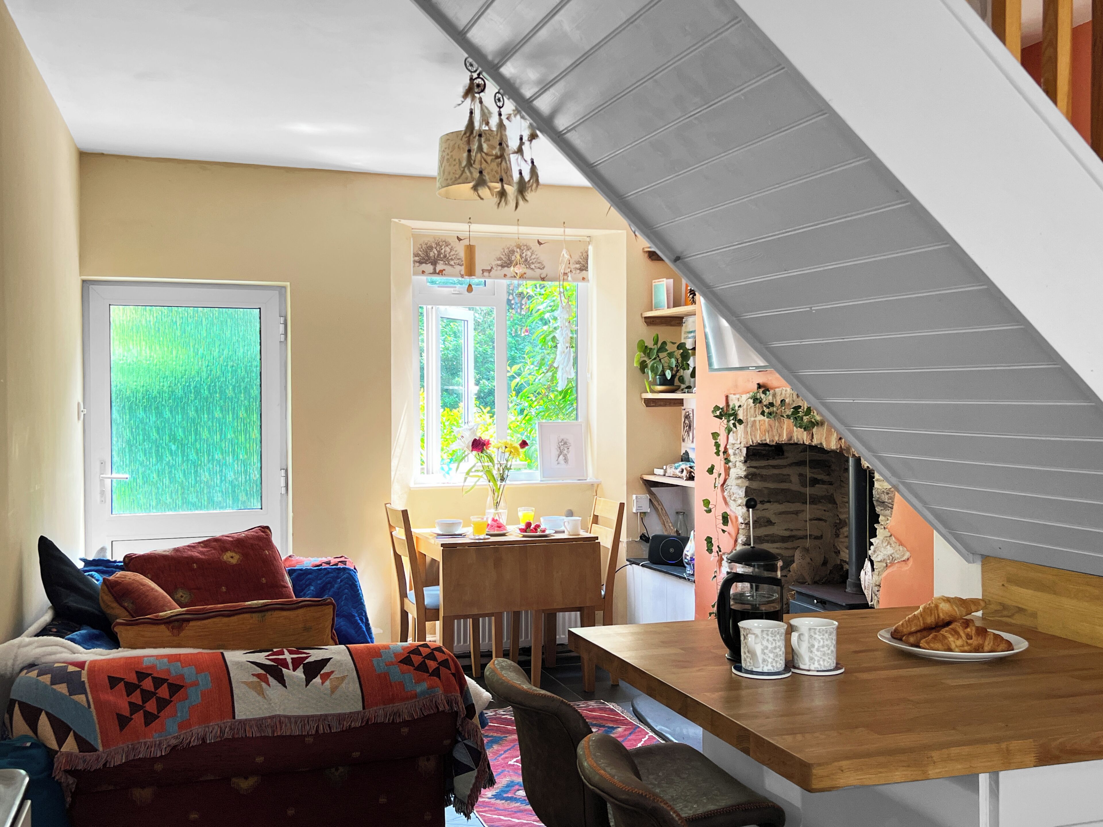 A cozy living room with a sofa, a dining table, and a fireplace.